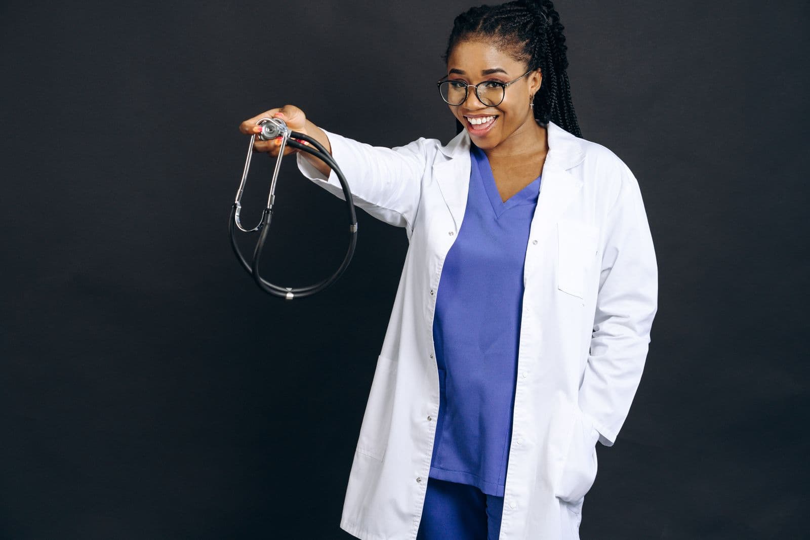 A smiling Caribbean doctor holding a stethoscope