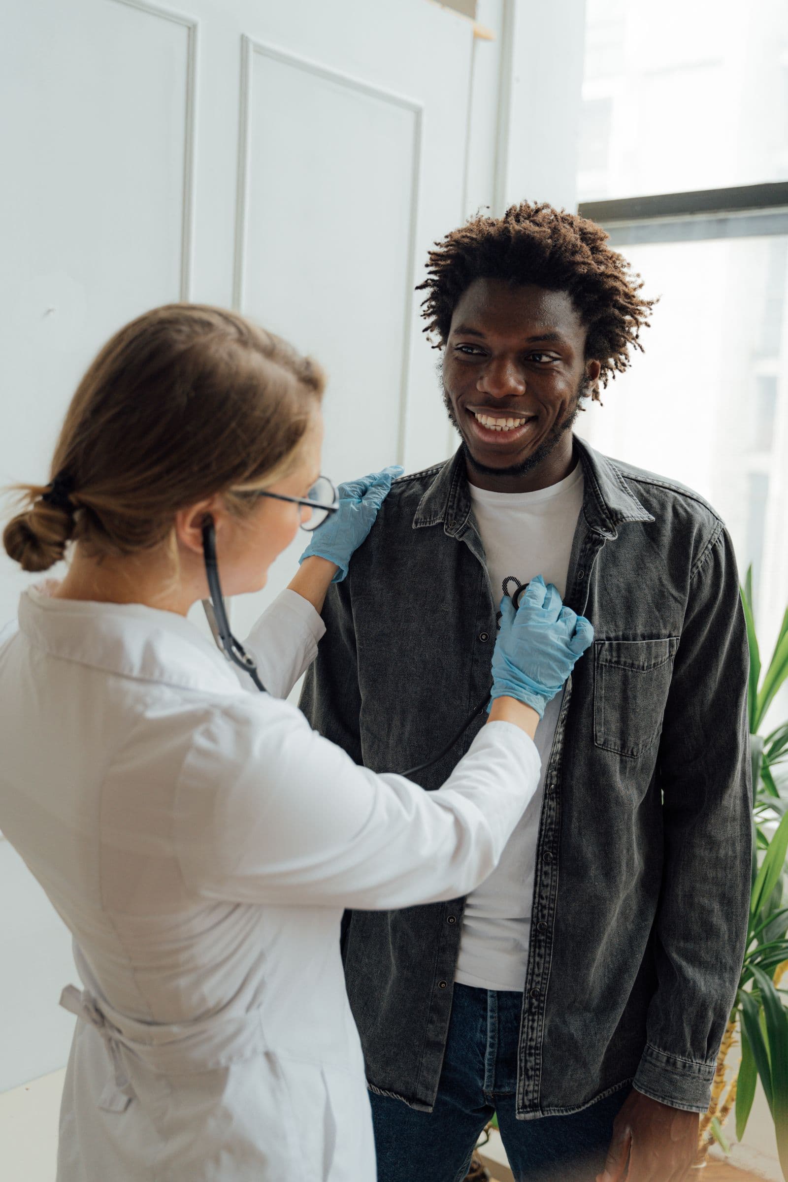 A Caribbean clinician listening to a patient's chest with a stethoscope