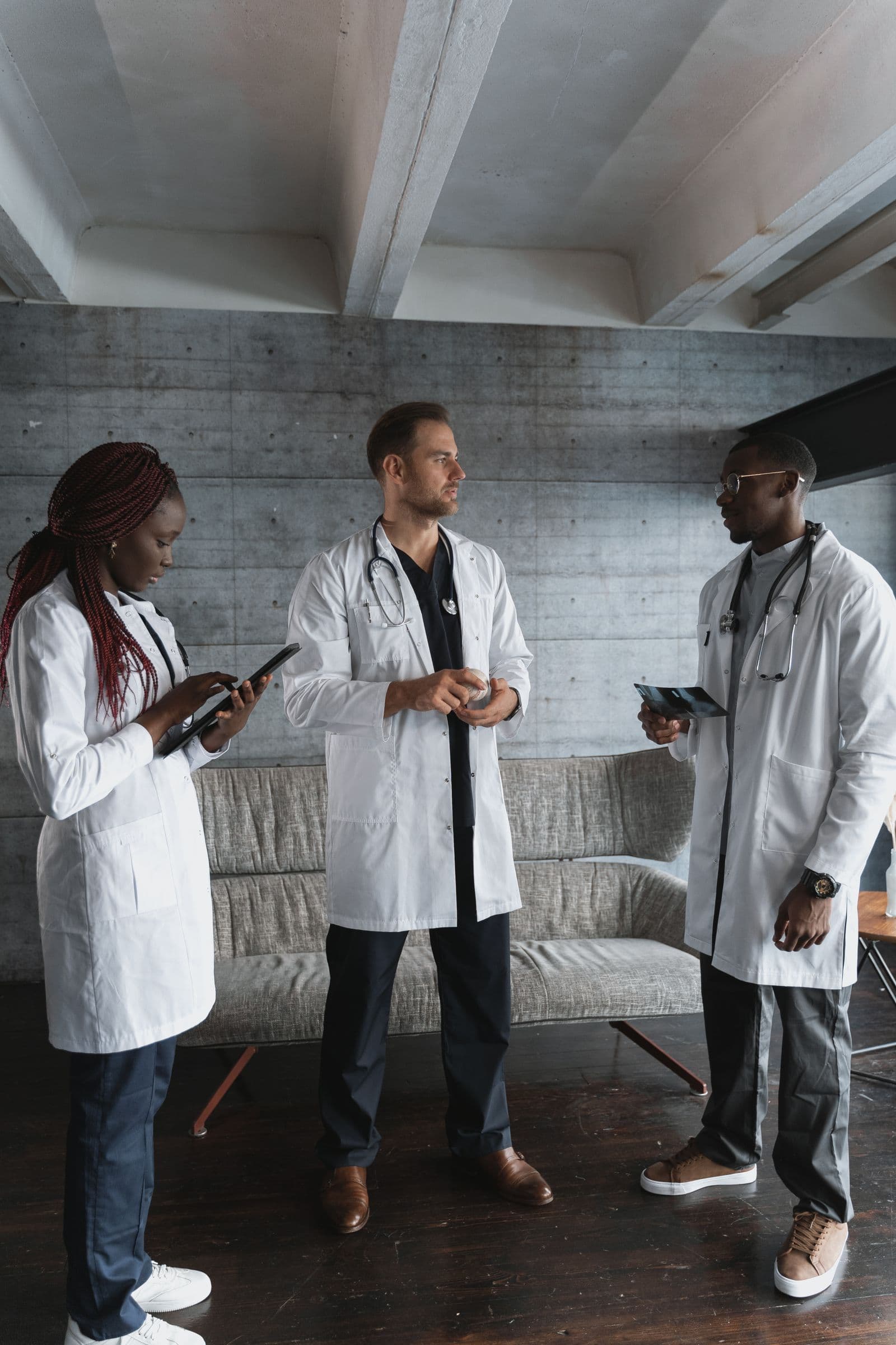 Three doctors in discussion in a hospital lounge
